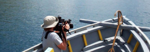 A cameraman collects footage on a boat
